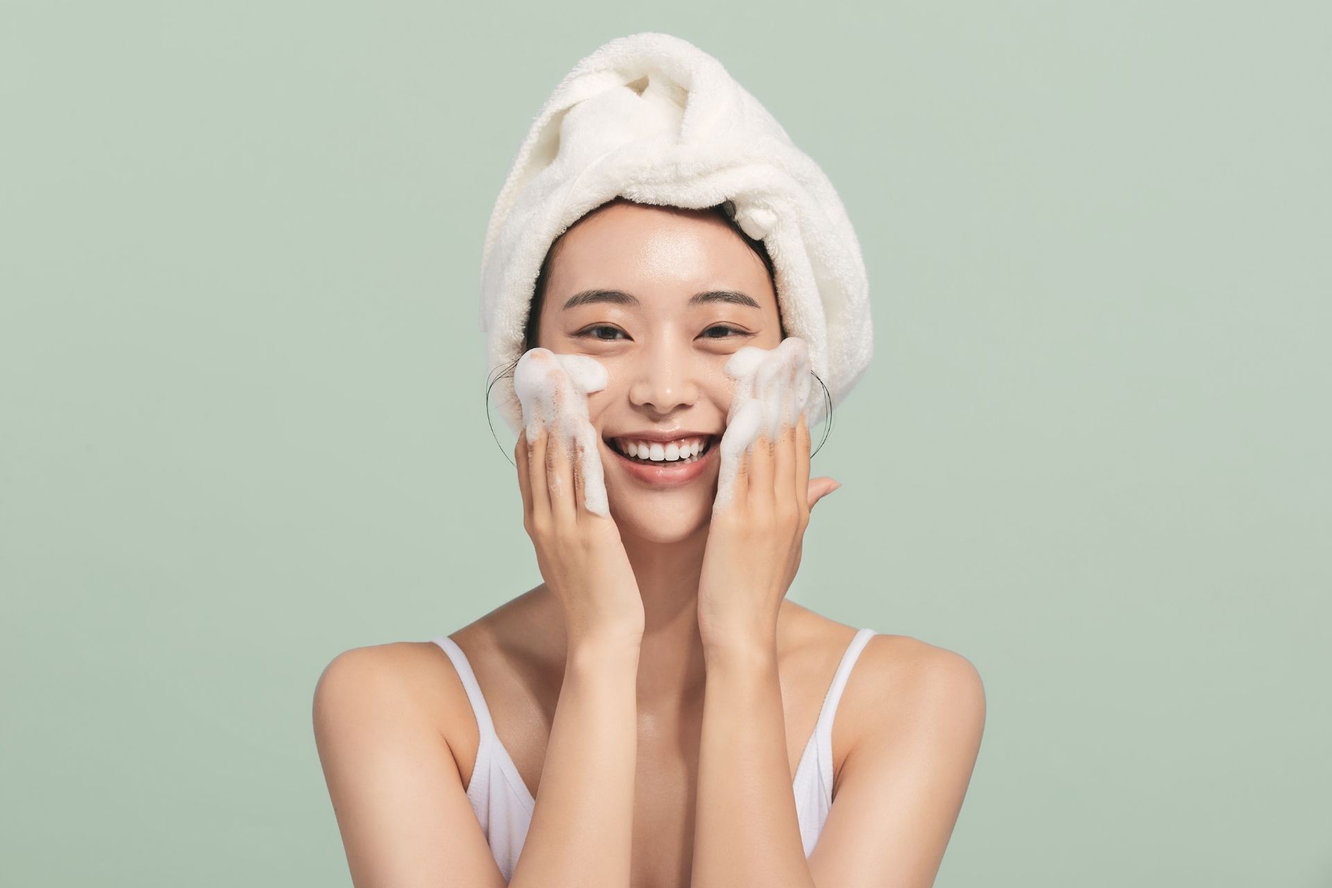 Frau wäscht ihr Gesicht mit Reinigungsschaum – K-Beauty Basics Hautpflege